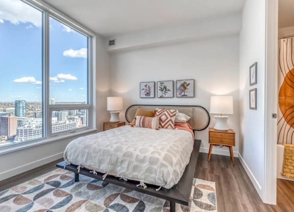 A bedroom with a large bed and a view of the city.