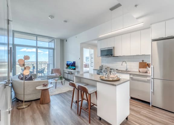 A modern kitchen with a refrigerator, sink, and cabinets.