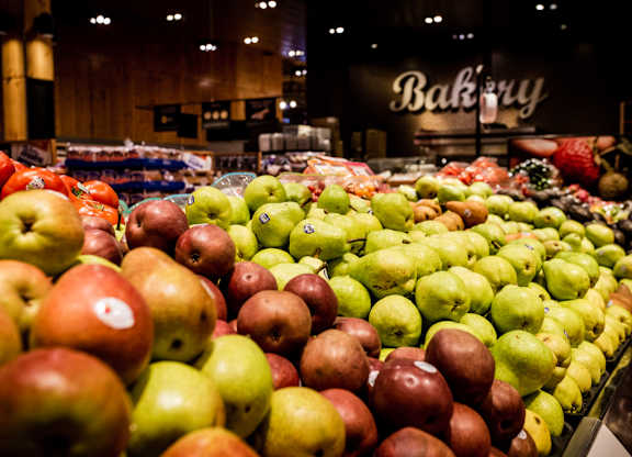 A bakery with a display of apples in the foreground.
