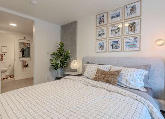 A bedroom with a large bed and pictures on the wall.