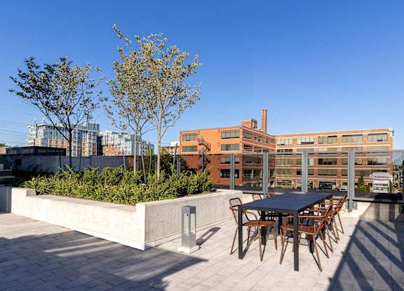 A table and chairs are set up on a rooftop patio.