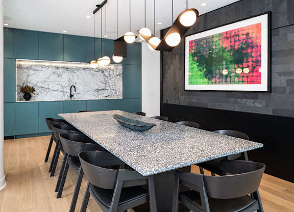 A modern dining room with a large table and chairs.