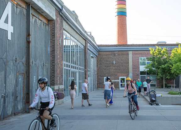 A person riding a bike in front of a building with a number 4 on it.