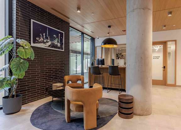 A room with a large chair and a potted plant.
