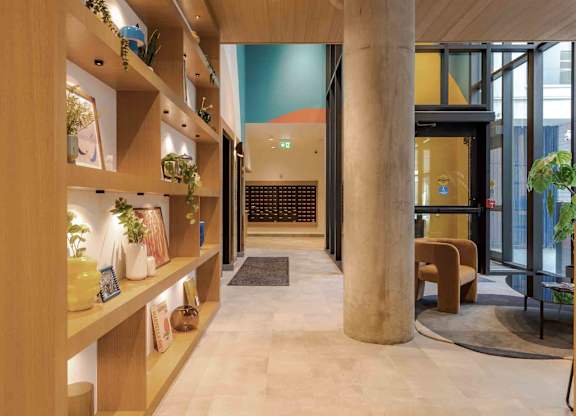 A hallway with wooden shelves on the sides and a bench in the middle.