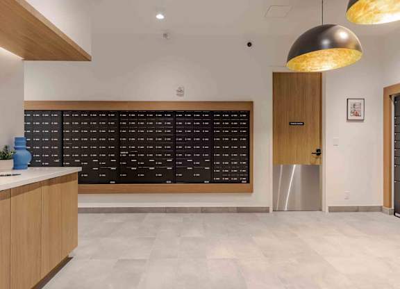 A modern office lobby with a reception desk and a wall of black chairs.