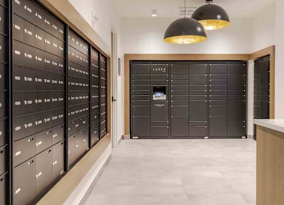 A hallway with a row of black filing cabinets on the left and a row of black lockers on the right.