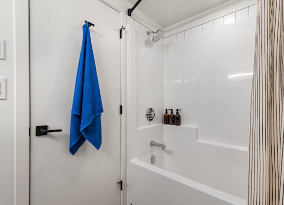 A blue towel is hanging on a black door handle.