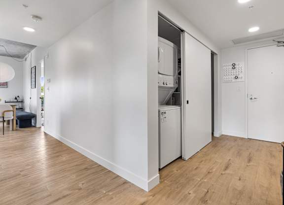 A kitchen with a refrigerator, oven, and a dining table with chairs.