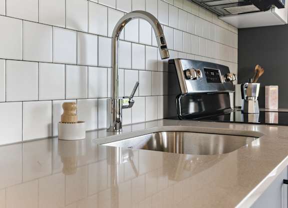 A kitchen with a sink and a black stove.