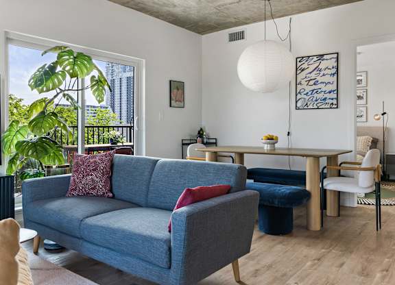 A living room with a blue couch and a white chair.