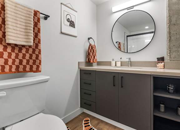 A bathroom with a toilet, sink, and a mirror.