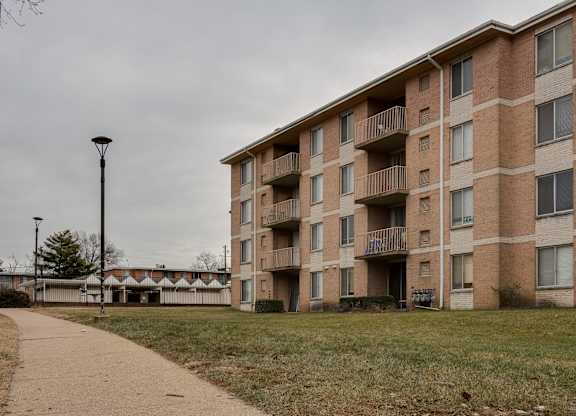A brick apartment building with a walkway in front.