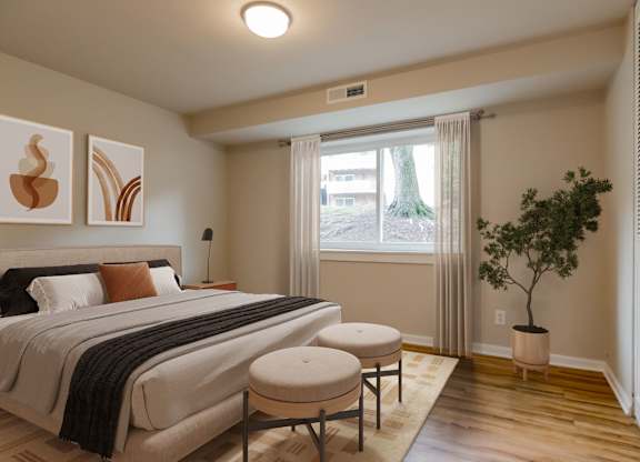 A bedroom with a large bed and a small tree.
