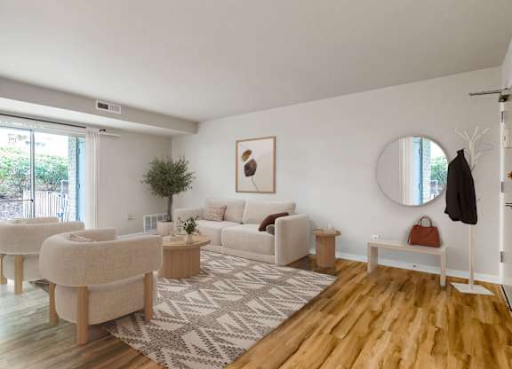A living room with a white couch and a rug.