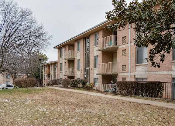 Apartment building with a tree in front of it.