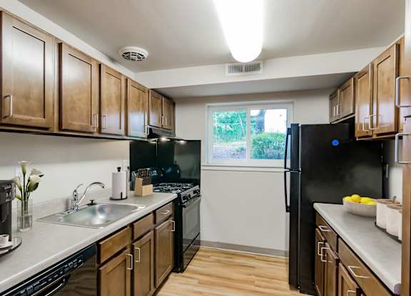 A kitchen with wooden cabinets and black appliances.