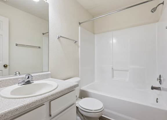 A white bathroom with a sink, toilet, and bathtub.