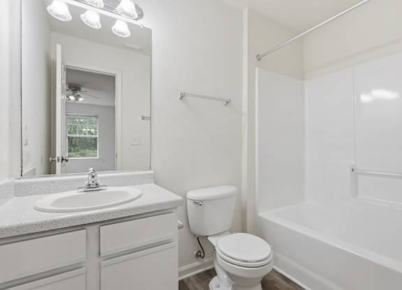A white bathroom with a sink, toilet, and bathtub.