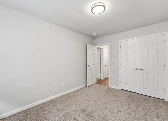 A room with two doors and a carpeted floor.
