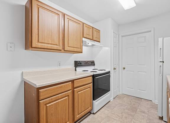 A kitchen with wooden cabinets and a white refrigerator.