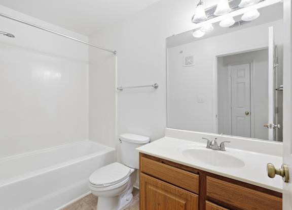 A white bathroom with a toilet, sink, and bathtub.
