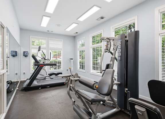 A spacious home gym with a treadmill, elliptical trainer, and a stationary bike.
