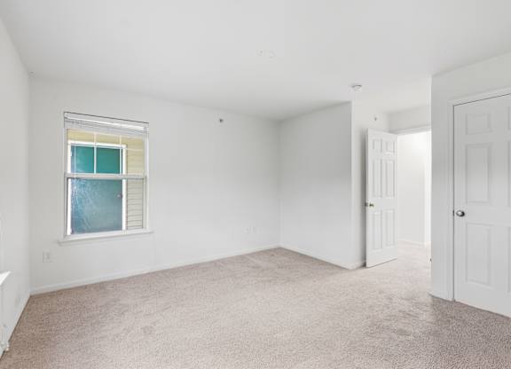 A room with a window and two doors.