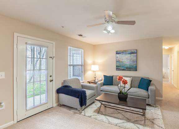 A living room with a grey couch, a coffee table, and a painting on the wall.