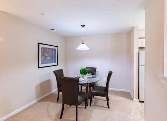 A dining room with a table and chairs.