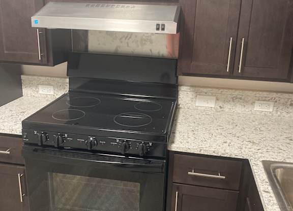 A kitchen with black appliances and a white refrigerator.