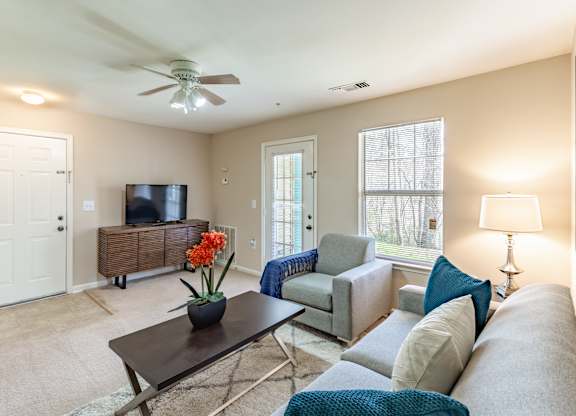 A living room with a couch, chair, and television.