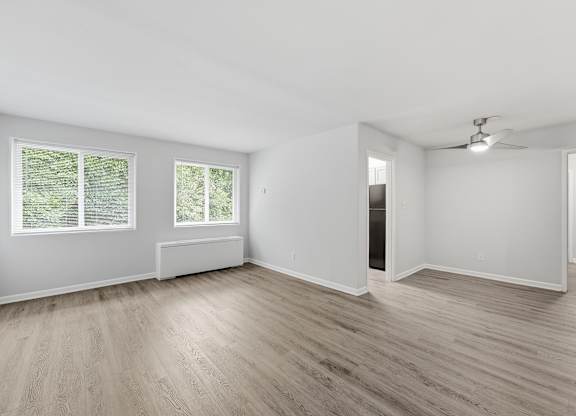 A room with wooden flooring and a ceiling fan.