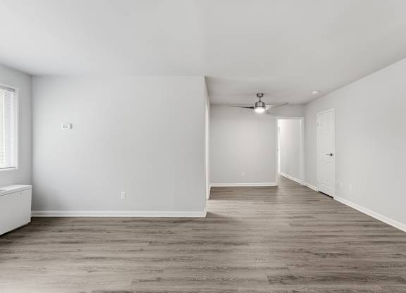 A room with wooden flooring and white walls.