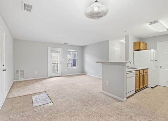 A kitchen area with a white fridge and cabinets.