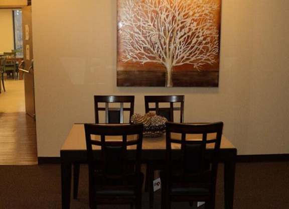 A brown table with two chairs and a vase on it.