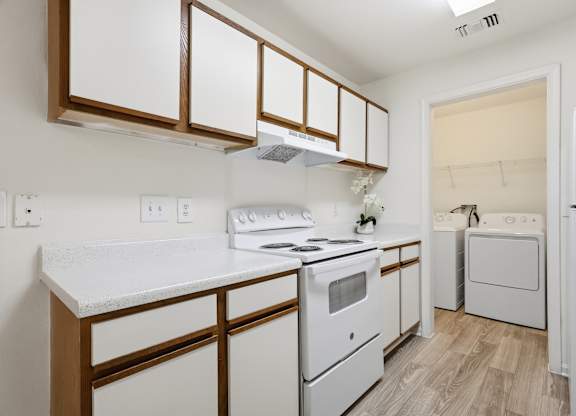 A white kitchen with a stove, oven, and refrigerator.