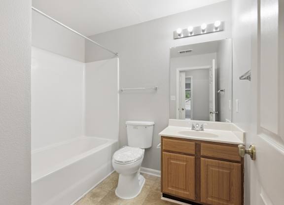 A white bathroom with a toilet, sink, and bathtub.