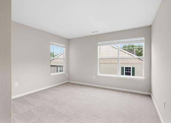 A spacious room with large, bright windows.