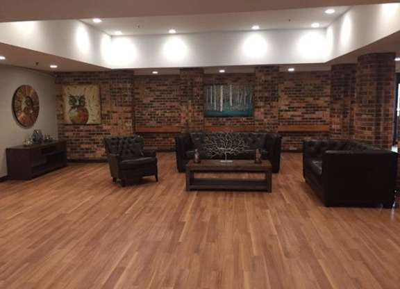 A living room with a brick wall and wooden floors.