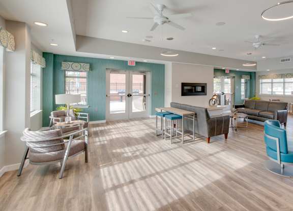 A spacious room with a blue and wood theme and a ceiling fan.