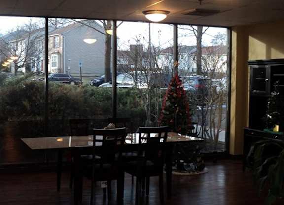 A dining room with a table and chairs and a Christmas tree.