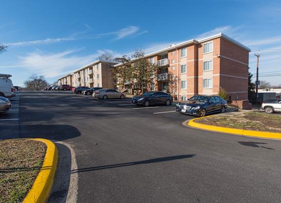 A parking lot with cars and apartment buildings in the background.