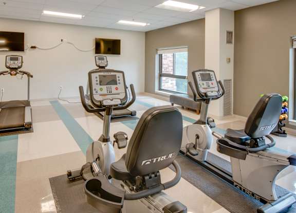 A gym with treadmills and elliptical machines.