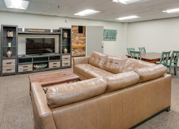 A living room with a brown leather couch and a wooden coffee table.