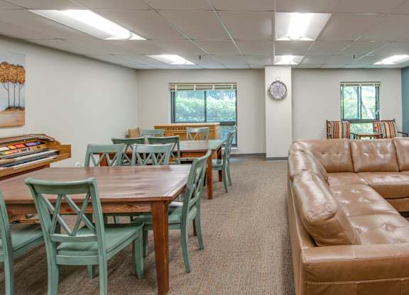 A room with a couch, chairs, and a table.
