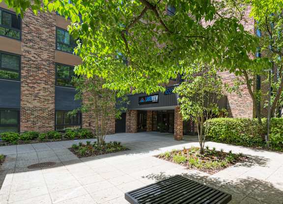 A courtyard with a brick building and a black bench.