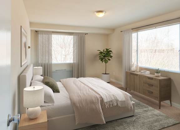 A bedroom with a bed, nightstand, and window.