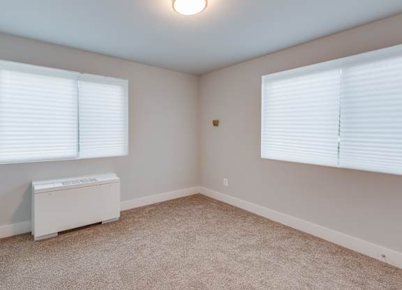 A room with a window and a white box on the floor.