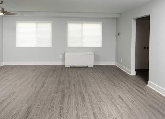 A room with a white sofa and a ceiling fan.